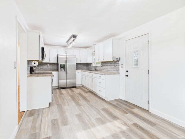 203 E Plum St, Frankton, IN 46044 - kitchen featuring stainless steel appliances, tasteful backsplash, light wood-style flooring, and white cabinets