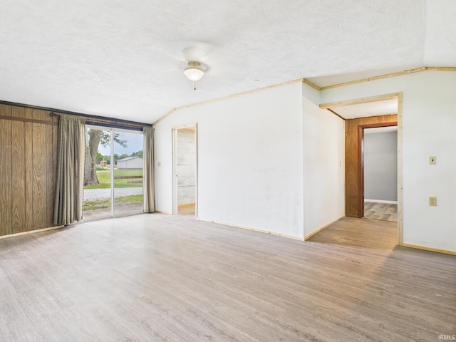 203 E Plum St, Frankton, IN 46044 - empty room featuring lofted ceiling, wood finished floors, and a textured ceiling