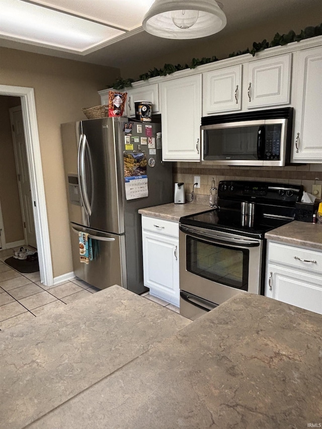 6933 Cleopatra Xing, Fort Wayne, IN 46818 - kitchen featuring appliances with stainless steel finishes, white cabinets, light tile patterned floors, and backsplash