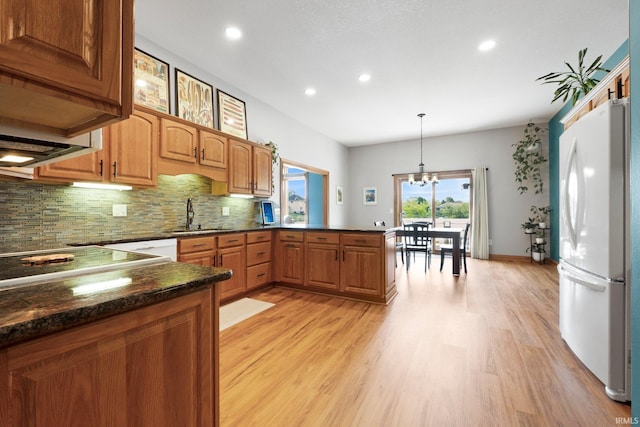 16619 Amethyst Pkwy, Fort Wayne, IN 46845 - kitchen with freestanding refrigerator, light wood-type flooring, decorative backsplash, recessed lighting, and a peninsula