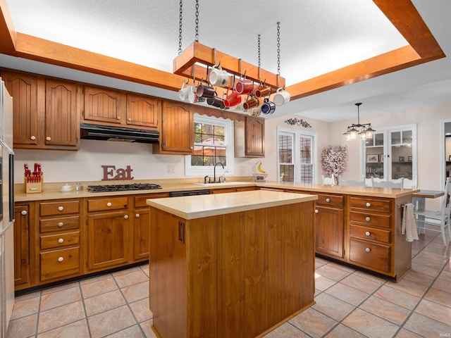 8220 Sakaden Pkwy, Fort Wayne, IN 46825 - kitchen with under cabinet range hood, a chandelier, a peninsula, and brown cabinetry