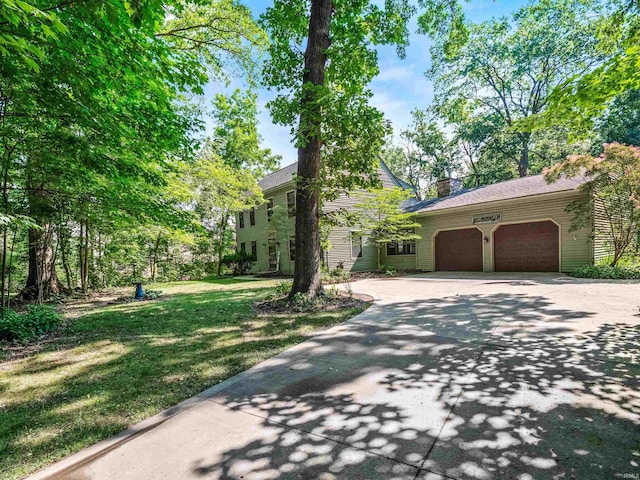 8220 Sakaden Pkwy, Fort Wayne, IN 46825 - view of front of property with an attached garage, concrete driveway, a front lawn, and a chimney