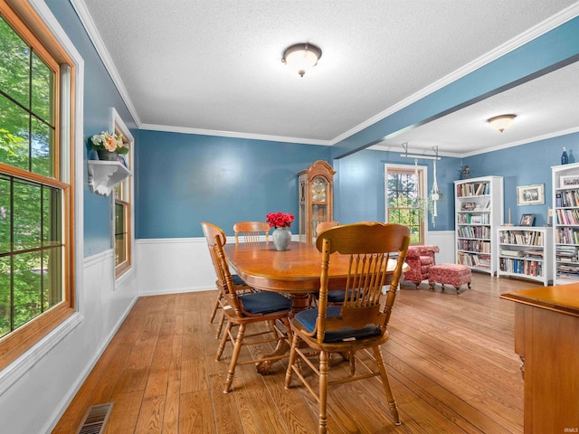 8220 Sakaden Pkwy, Fort Wayne, IN 46825 - dining room with a textured ceiling, wainscoting, wood-type flooring, and ornamental molding