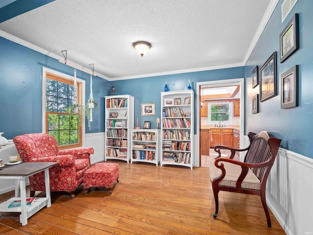 8220 Sakaden Pkwy, Fort Wayne, IN 46825 - living area with a textured ceiling, plenty of natural light, light wood finished floors, wainscoting, and crown molding