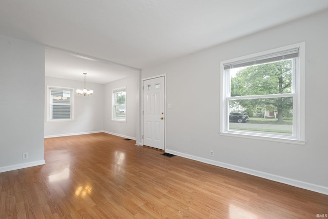 1738 Sunnymede Ave, South Bend, IN 46615 - unfurnished living room featuring a chandelier and light wood-style floors