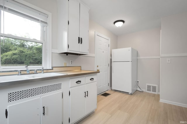 1738 Sunnymede Ave, South Bend, IN 46615 - kitchen featuring freestanding refrigerator, white cabinetry, and light countertops