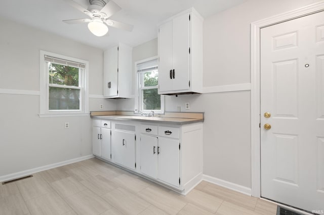 1738 Sunnymede Ave, South Bend, IN 46615 - kitchen with healthy amount of natural light, white cabinets, ceiling fan, and light countertops