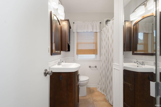 1738 Sunnymede Ave, South Bend, IN 46615 - bathroom featuring two vanities, tile patterned floors, and wainscoting