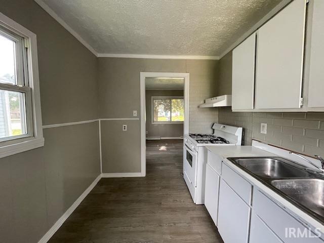 106 N Wellington St, South Bend, IN 46619 - kitchen with white gas range, under cabinet range hood, a textured ceiling, dark wood-style flooring, and white cabinets
