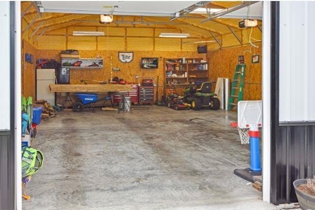 7132 W 350 N, West Lafayette, IN 47906 - garage with freestanding refrigerator, a garage door opener, and a workshop area