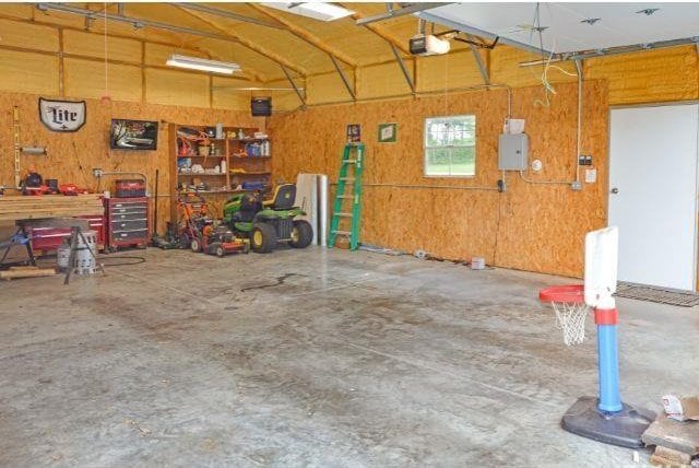 7132 W 350 N, West Lafayette, IN 47906 - garage with a garage door opener, a workshop area, and wooden walls