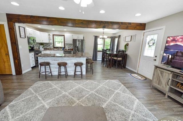 7132 W 350 N, West Lafayette, IN 47906 - kitchen featuring stainless steel appliances, white cabinetry, wood finished floors, a breakfast bar, and recessed lighting