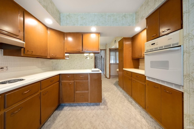 1202 Park Ave, New Haven, IN 46774 - kitchen with white oven, light countertops, brown cabinetry, wallpapered walls, and backsplash