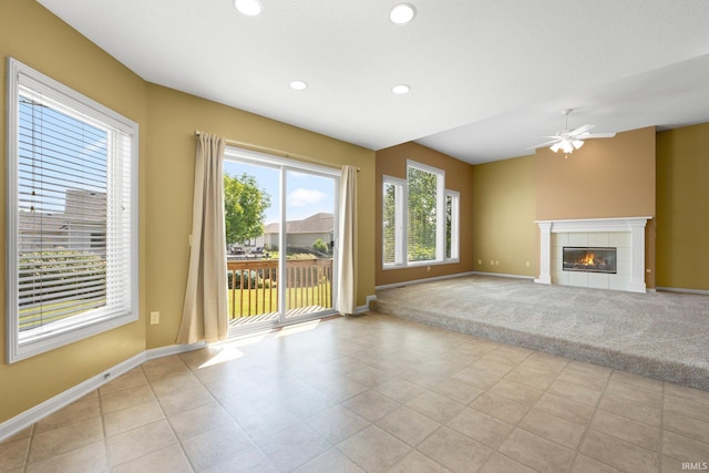 12828 Palazzo Blvd, Fort Wayne, IN 46845 - unfurnished living room featuring a tiled fireplace, ceiling fan, recessed lighting, light tile patterned flooring, and light colored carpet