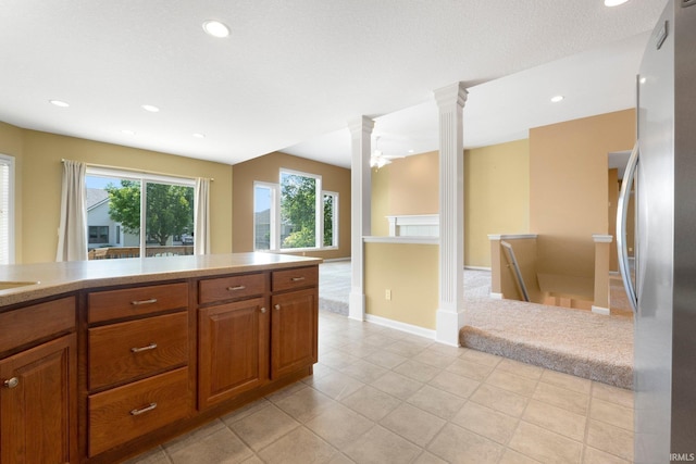 12828 Palazzo Blvd, Fort Wayne, IN 46845 - kitchen featuring freestanding refrigerator, decorative columns, brown cabinetry, light countertops, and recessed lighting