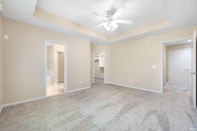 12828 Palazzo Blvd, Fort Wayne, IN 46845 - unfurnished bedroom with a tray ceiling, light carpet, a walk in closet, a closet, and ceiling fan