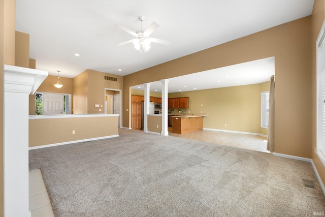 12828 Palazzo Blvd, Fort Wayne, IN 46845 - unfurnished living room featuring ceiling fan, light colored carpet, light tile patterned flooring, recessed lighting, and decorative columns
