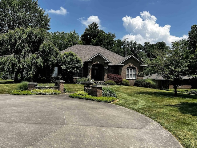 348 N Birdie Ln, Montgomery, IN 47558 - ranch-style home with a front yard, brick siding, and roof with shingles
