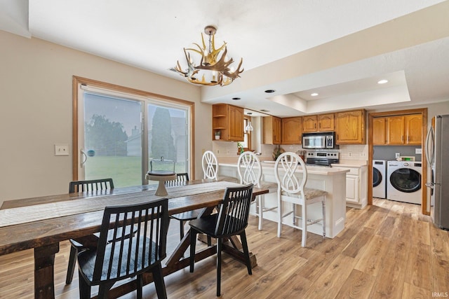 9026 Wallen Ln, Fort Wayne, IN 46825 - dining room with independent washer and dryer, a chandelier, a raised ceiling, light wood finished floors, and recessed lighting