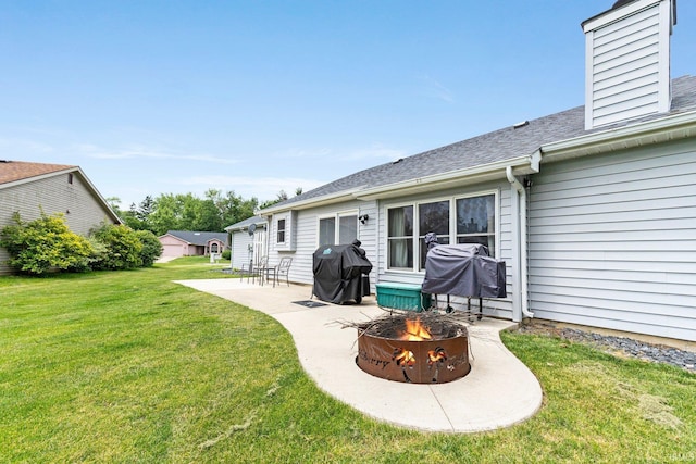 9026 Wallen Ln, Fort Wayne, IN 46825 - back of house featuring an outdoor fire pit, a patio, a yard, a shingled roof, and a chimney