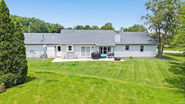 9026 Wallen Ln, Fort Wayne, IN 46825 - back of property featuring a patio area, a yard, a shingled roof, and a fire pit