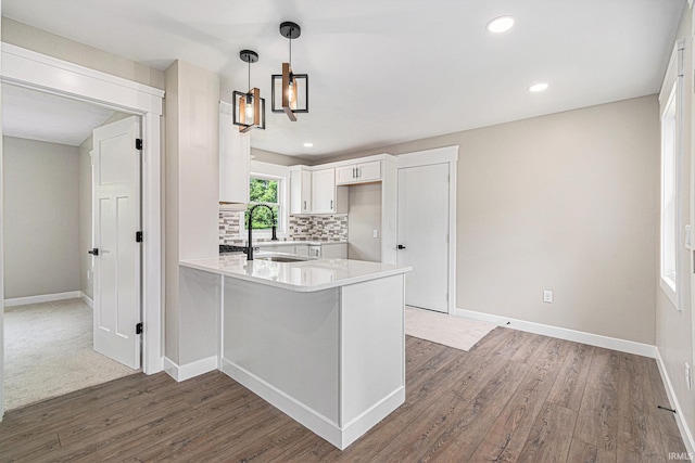 121 W Front St, New Carlisle, IN 46552 - kitchen with a peninsula, decorative backsplash, wood finished floors, light countertops, and white cabinets