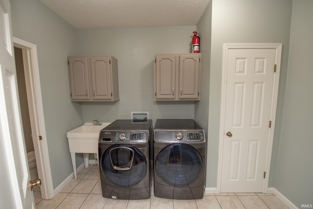 3801 W Capilano Dr, West Lafayette, IN 47906 - laundry area featuring independent washer and dryer, cabinet space, and light tile patterned floors