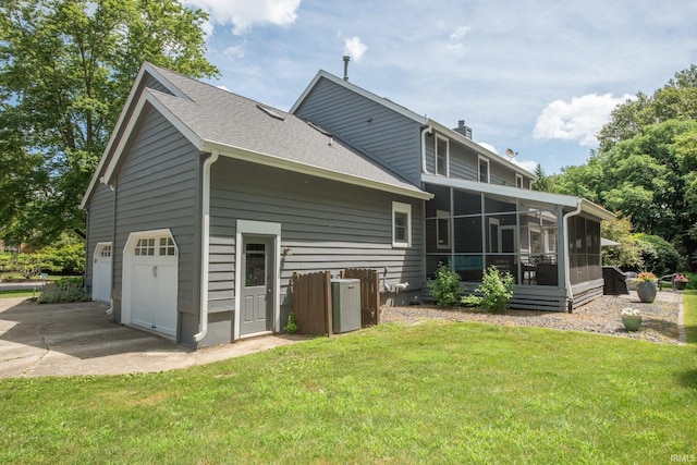 3801 W Capilano Dr, West Lafayette, IN 47906 - rear view of house featuring a sunroom, concrete driveway, a yard, a shingled roof, and a chimney