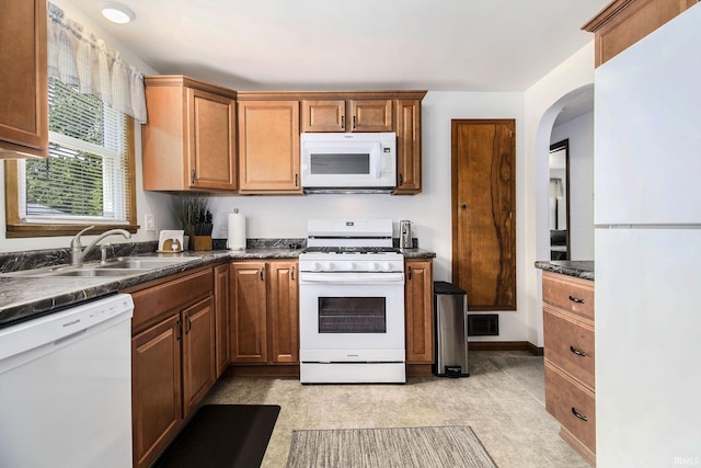 825 W Catalpa Dr, Mishawaka, IN 46545 - kitchen featuring white appliances, dark countertops, and arched walkways