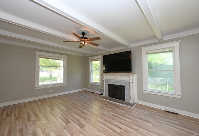 421 S Franklin St, Winamac, IN 46996 - unfurnished living room with beamed ceiling, healthy amount of natural light, light wood-style floors, a fireplace, and ceiling fan