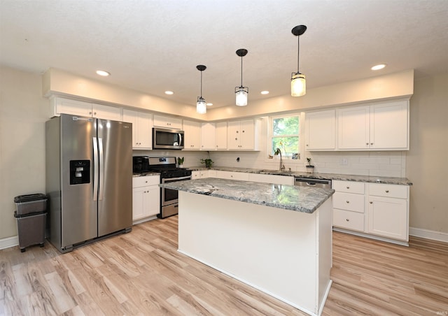 421 S Franklin St, Winamac, IN 46996 - kitchen with stainless steel appliances, light wood finished floors, white cabinetry, a center island, and recessed lighting