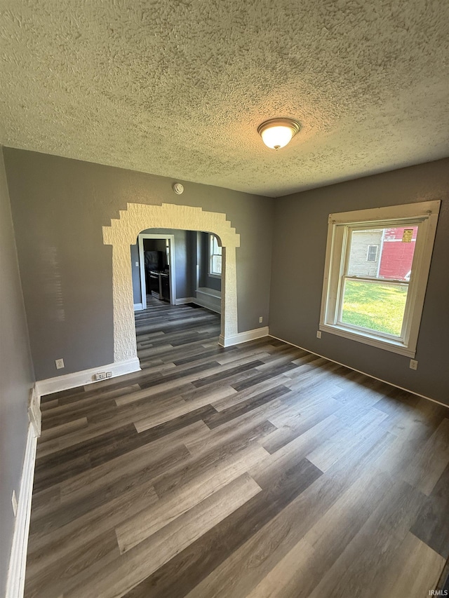 628 Birdsell St, South Bend, IN 46628 - unfurnished room with arched walkways, a textured ceiling, dark wood finished floors, and healthy amount of natural light