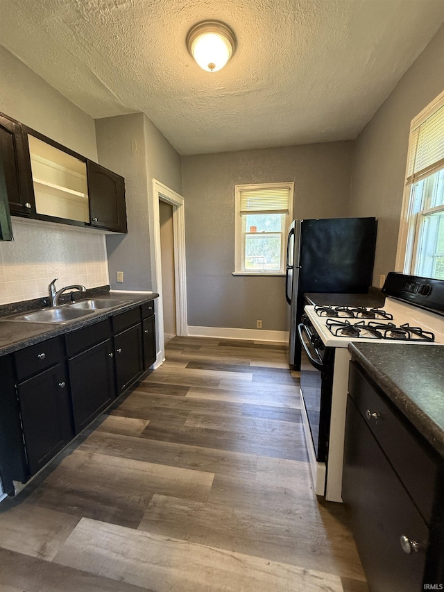 628 Birdsell St, South Bend, IN 46628 - kitchen with black range with gas stovetop, dark countertops, a textured ceiling, dark wood finished floors, and tasteful backsplash