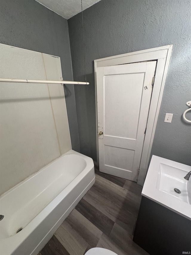 628 Birdsell St, South Bend, IN 46628 - full bath with a textured wall, wood finished floors, vanity, and a tub