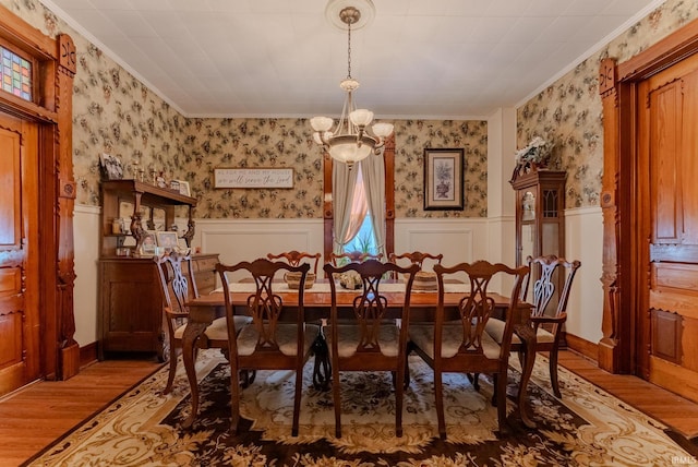 240 Elm St, Wabash, IN 46992 - dining space featuring wallpapered walls, crown molding, wainscoting, wood finished floors, and a chandelier