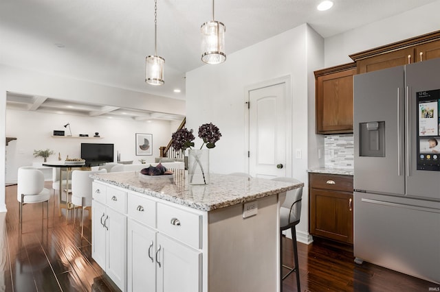 3032 Treviso Way, Fort Wayne, IN 46814 - kitchen with stainless steel fridge, a kitchen island, open floor plan, a kitchen bar, and dark wood-type flooring
