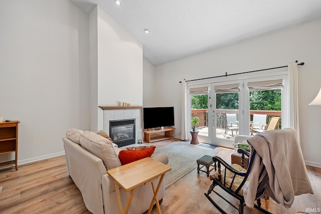 323 E Pine Ave, West Lafayette, IN 47906 - living room featuring a tiled fireplace, light wood-style flooring, high vaulted ceiling, recessed lighting, and french doors