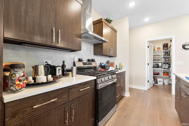 12116 Fazio Dr, Fort Wayne, IN 46818 - kitchen with wall chimney exhaust hood, appliances with stainless steel finishes, light wood finished floors, tasteful backsplash, and light countertops