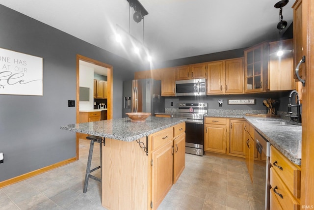 2608 Creeping Phlox Cv, Fort Wayne, IN 46818 - kitchen featuring appliances with stainless steel finishes, a kitchen island, light stone counters, a breakfast bar, and glass insert cabinets