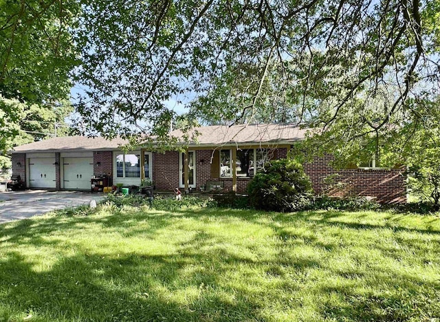 9924 Washington St, Leo, IN 46765 - ranch-style home with brick siding, an attached garage, a front lawn, and driveway