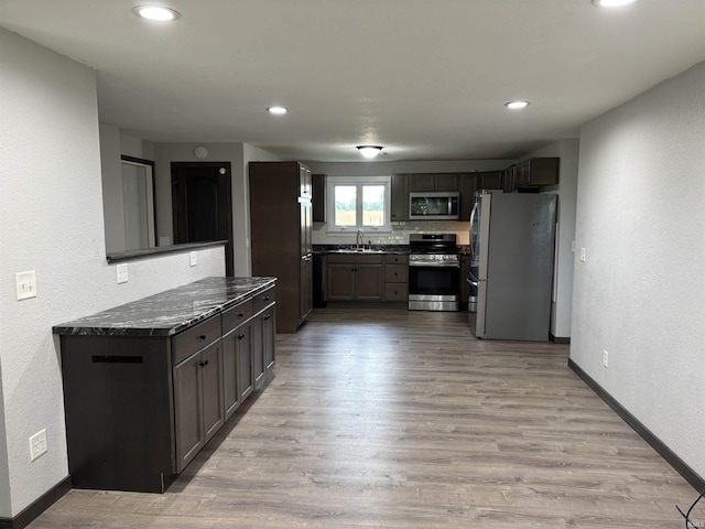 140 W 100 S Rd, Lagrange, IN 46761 - kitchen with stainless steel appliances, light wood finished floors, recessed lighting, a textured wall, and dark stone counters
