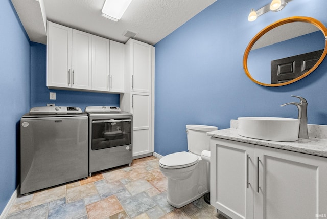 2624 E Stalf Rd, Columbia City, IN 46725 - bathroom featuring washer and clothes dryer, vanity, stone finish flooring, and a textured ceiling