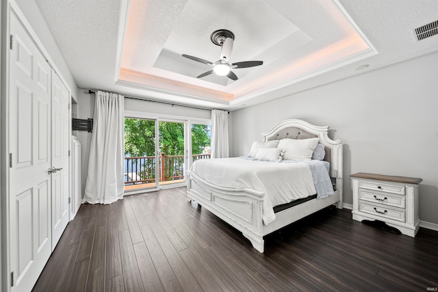 2624 E Stalf Rd, Columbia City, IN 46725 - bedroom with a tray ceiling, access to exterior, dark wood-style floors, and a ceiling fan
