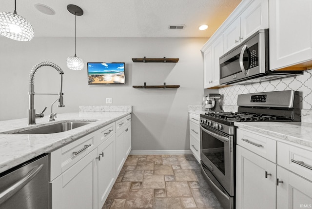 2624 E Stalf Rd, Columbia City, IN 46725 - kitchen with appliances with stainless steel finishes, backsplash, white cabinets, light stone counters, and pendant lighting
