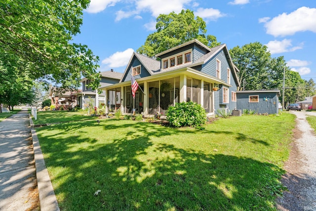 321 W Michigan St, New Carlisle, IN 46552 - view of front facade with a sunroom and a front yard