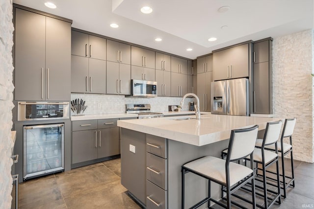 203 E Berry St Unit 1004, Fort Wayne, IN 46802 - kitchen with stainless steel appliances, gray cabinets, beverage cooler, backsplash, and recessed lighting