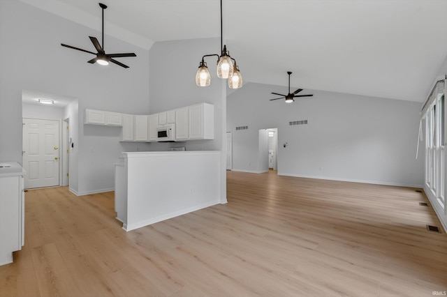 50588 Carrington Place Dr, South Bend, IN 46637 - kitchen with ceiling fan, high vaulted ceiling, white microwave, white cabinetry, and open floor plan
