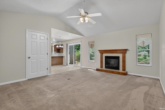 51613 Emmons Rd, South Bend, IN 46637 - unfurnished living room featuring lofted ceiling, a tiled fireplace, light carpet, and ceiling fan