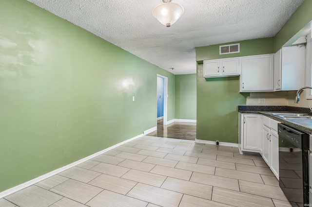 4648 Parkerdale Dr, Fort Wayne, IN 46815 - kitchen with black dishwasher, dark countertops, a textured ceiling, and white cabinetry
