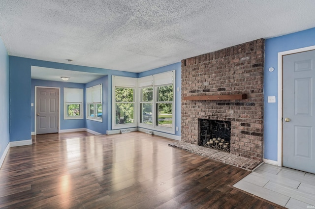 4648 Parkerdale Dr, Fort Wayne, IN 46815 - unfurnished living room featuring a textured ceiling, wood finished floors, and a fireplace